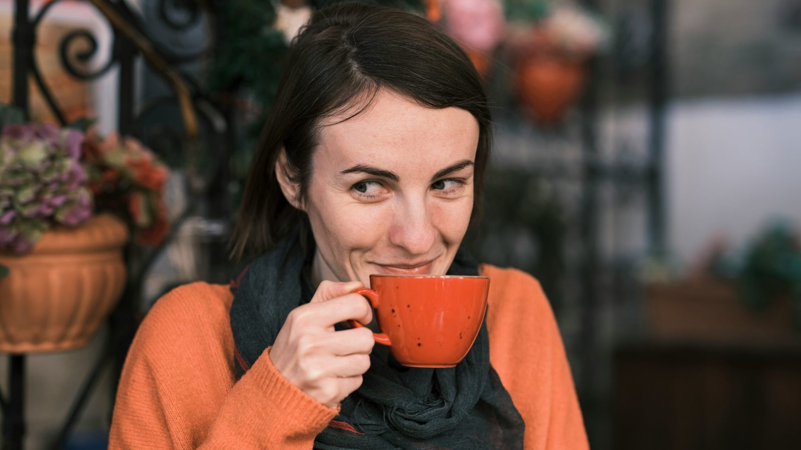 A smiling woman holding a mug of red clover tea