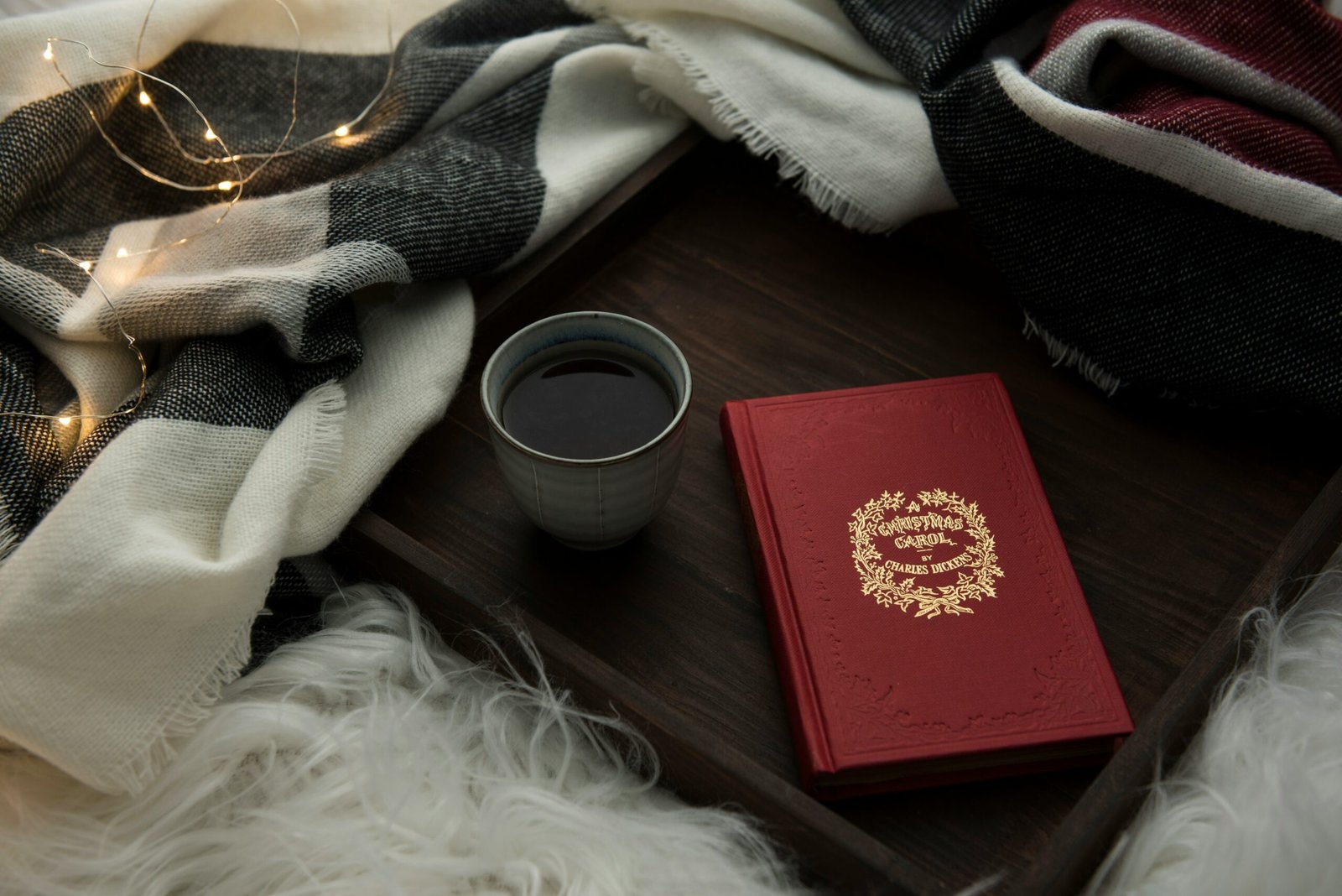 Cup of herbal red clover tea sitting beside a book on a wooden table