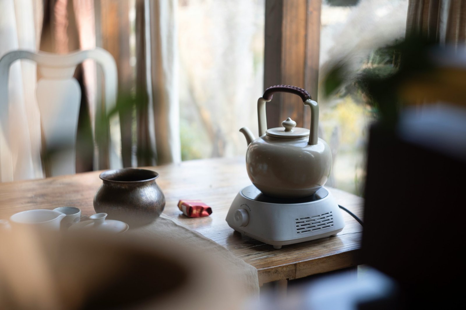 Steaming cup of red clover herbal tea on wooden table