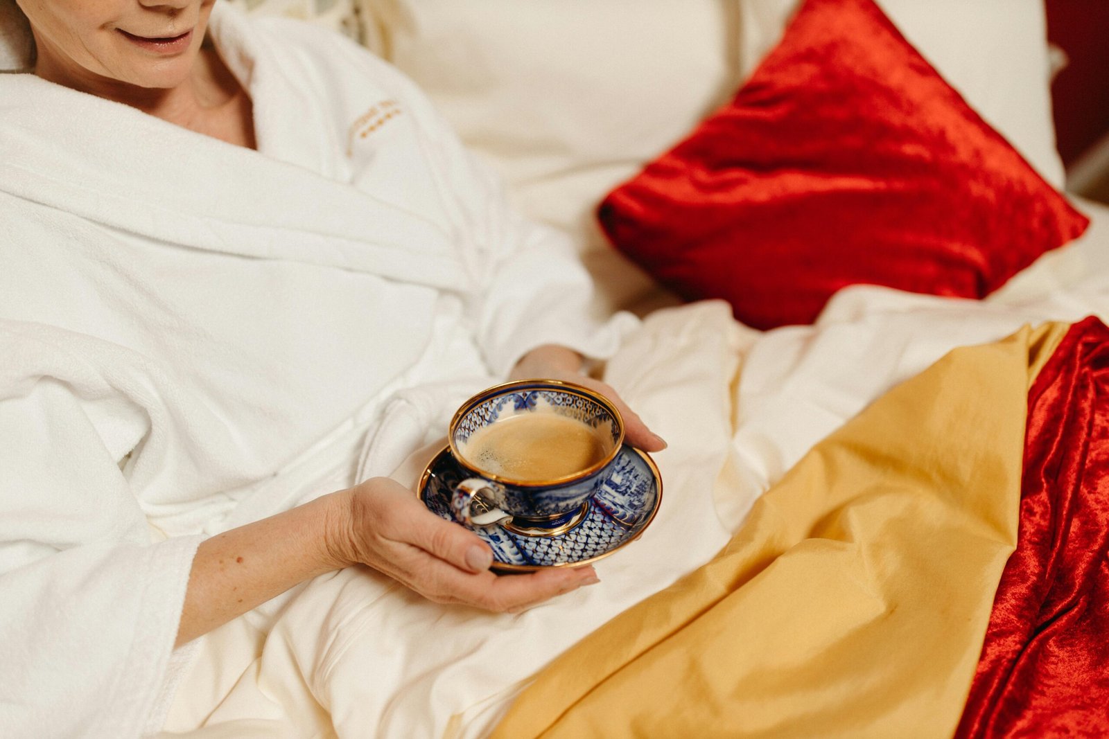 Woman enjoying red clover tea in a cozy bedroom setting
