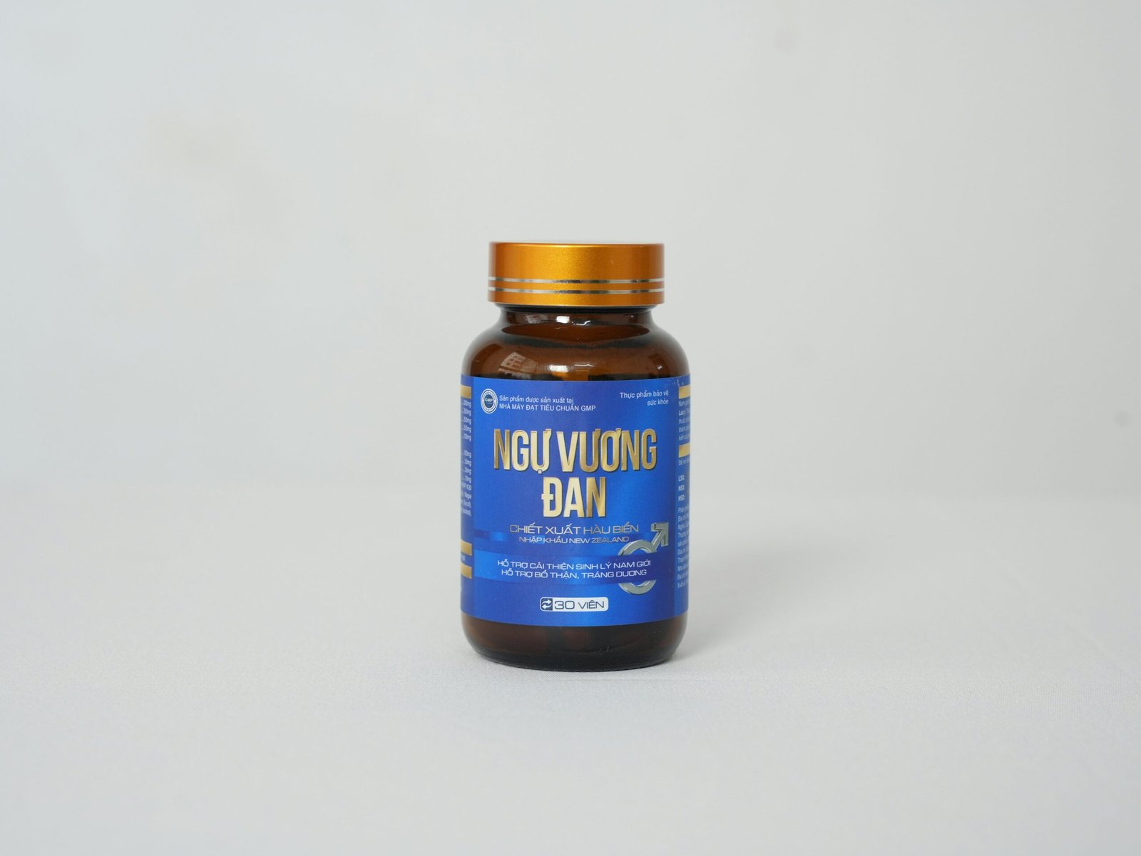 A steaming mug of red clover tea on a wooden table next to fresh clover flowers.