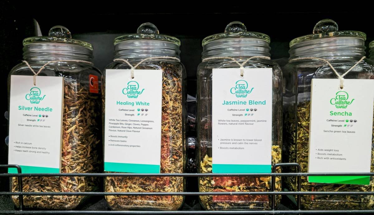 A steaming mug of red clover tea with dried petals floating on top.