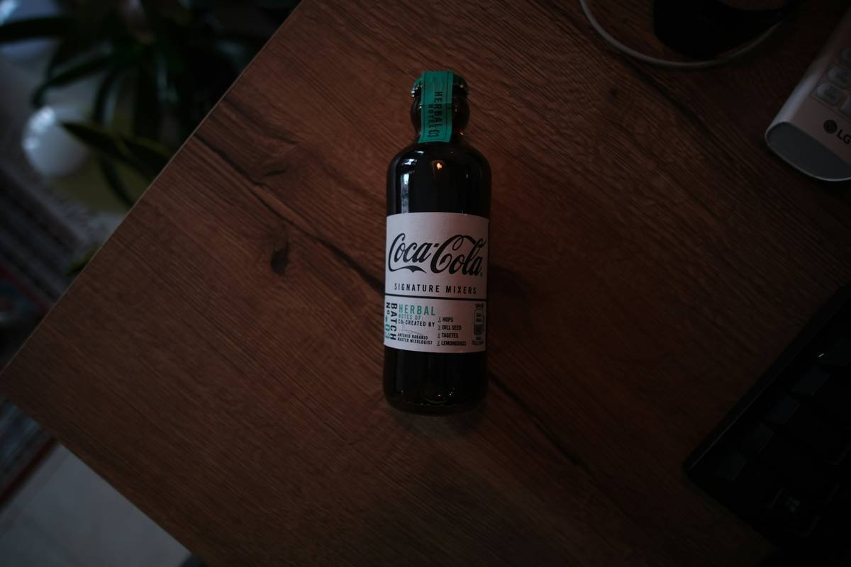 Red clover herbal tea leaves steeping in hot water inside a transparent mug
