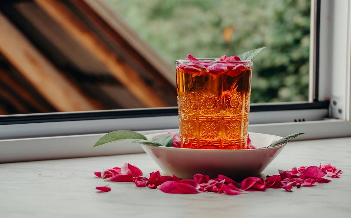 Close-up photo of brewing red clover tea in a glass teapot